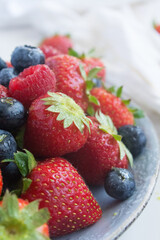 strawberries, raspberries and blueberries on a plate. close up