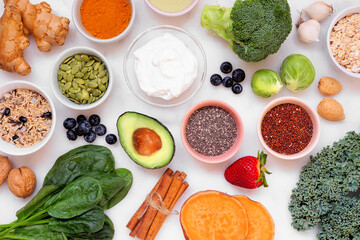 Set of healthy food ingredients. Overhead view table scene on a white marble background. Super food...