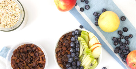 Cooking breakfast. Oatmeal with fruits, dried fruits and berries. Copy space.