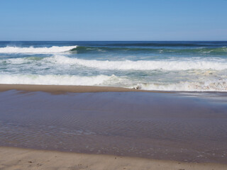 Beach landscape in the Atlantic ocean, with white waves in the water