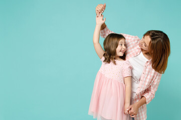 Happy woman in pink clothes have fun with cute child baby girl 5-6 years old. Mommy little kid daughter dancing celebrate isolated on pastel blue background studio. Mother's Day love family concept.