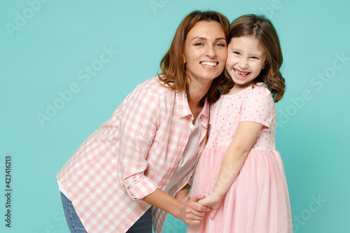Happy woman in pink clothes have fun with cute child baby girl 5-6 years old. Mommy little kid daughter look camera isolated on pastel blue azure background studio. Mother's Day love family concept.