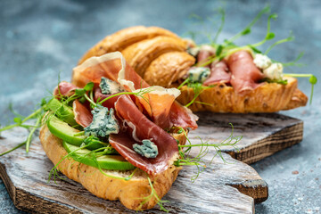 Open sandwich with prosciutto or jamon, blue cheese, avocado, microgin. Mediterranean appetizer. Breakfast concept