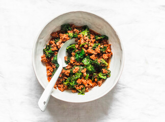 Bolognese sauce with kale on a light background, top view