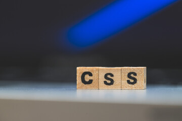CSS web language: Wooden cubes with letters “CSS” lying on a laptop, concept for style sheet...