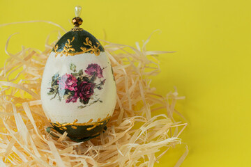 Colorful Easter egg on a yellow background with a painted rose