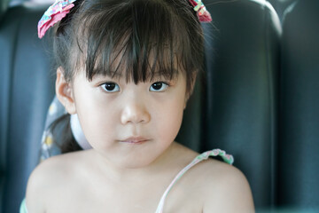 A big-eyed Asian girl looking at the photographer a picture