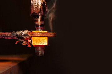 closeup calcining hot metal steel gear parts in a factory induction furnace with smoke
