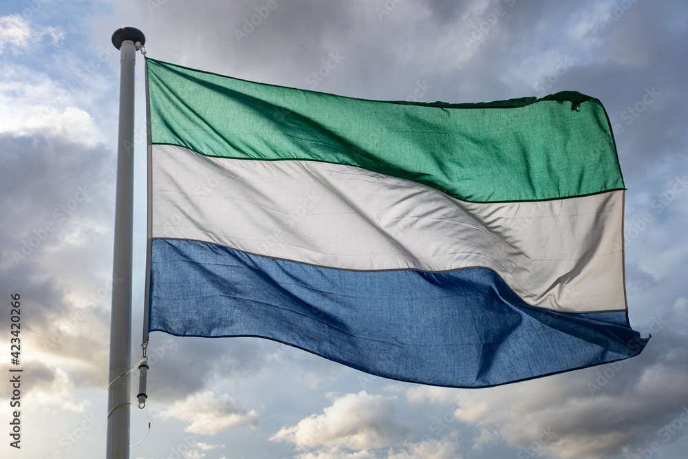 Wall mural sierra leone flag waving against cloudy sky