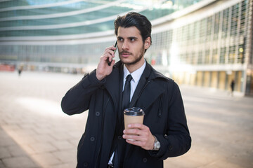 Businessman talking on the phone and drinking coffee
