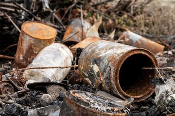 A rusty cans which were pressed down, burned and thrown away as ecology problem