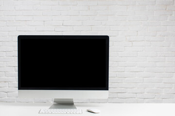 Working place, computer on white brick wall background