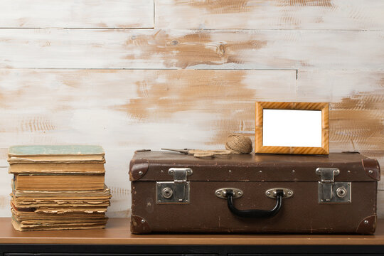 Aged old-fashioned object, suitcase, photo frame on wooden wall background