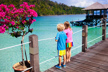 Kids on tropical beach. Child on resort jetty.