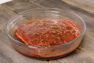 marinated piece of meat in a glass bowl. food concept