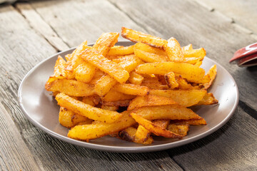 French fries with cheese sauce on wooden background. food concept
