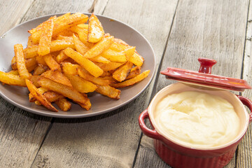 French fries with cheese sauce on wooden background. food concept