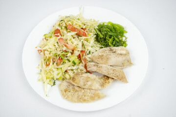 diet dish on a plate with fresh salad with cabbage, tomatoes, greens and chicken breast