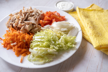Shaurma, burrito, chicken roll or pita with chicken, fresh vegetables, cream sauce and corn flour lavash