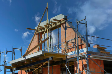 Gerüst an einer frei stehenden Giebelmauerung eines neugebauten Wohnhauses im Rohbau