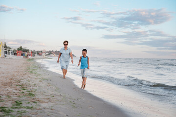 summer vacation at sea. Boy and senior woman at seaside. Grandmother with grandchild are resting on sea, running on beach having fun at summer holiday. Active parents, people activity with children.