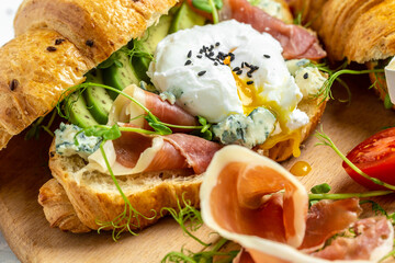 Croissant with prosciutto, poached egg, jamon, blue, cheese, avocado, microgin and cherry tomatoes....