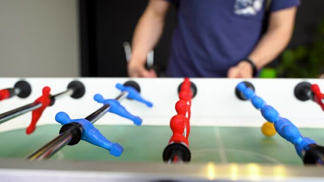 Table football game, kicker tournament. The camera jerks as the ball is thrown. Selective focus on players. St Petersburg, Russia - 27 Mar 2021