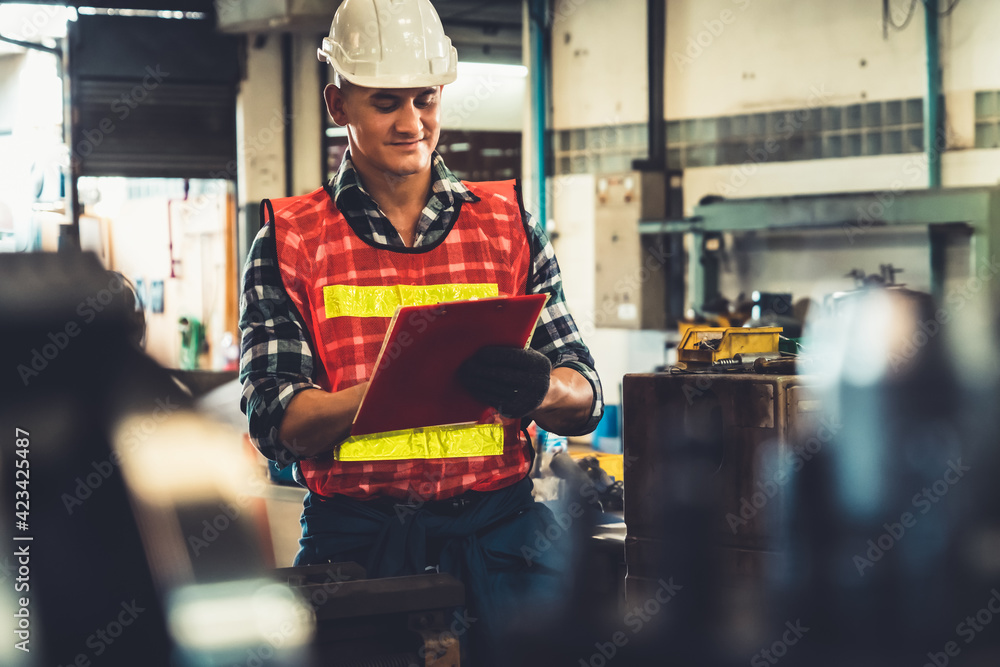 Poster manufacturing worker working with clipboard to do job procedure checklist . factory production line 