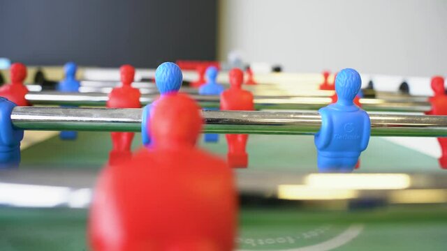 Table football game, kicker tournament. The camera jerks as the ball is thrown. Selective focus on players. St Petersburg, Russia - 27 Mar 2021