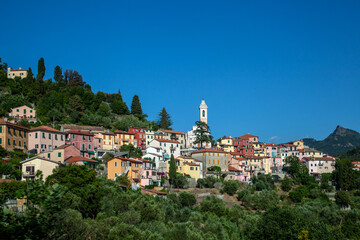 Fototapeta na wymiar Wonderful view of the Italian village in the mountains. Temples and houses among the greenery.