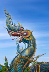Fototapeta na wymiar Dragon guard - exterior detail of Famous Wat Rong Suea Ten, or Blue Temple in Chiang Rai, Northern Thailand