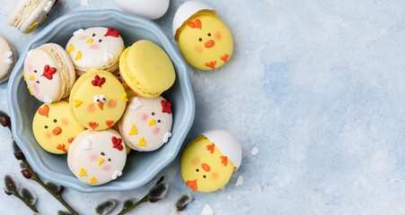 Easter dessert macarons chicks on a blue background. Easter treat, symbol. Copy space. Top view