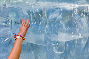 a child touching a wall of ice blocks