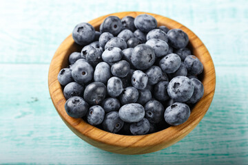 Fresh blueberries in a wooden bowl. Healthy and dietary food concept.