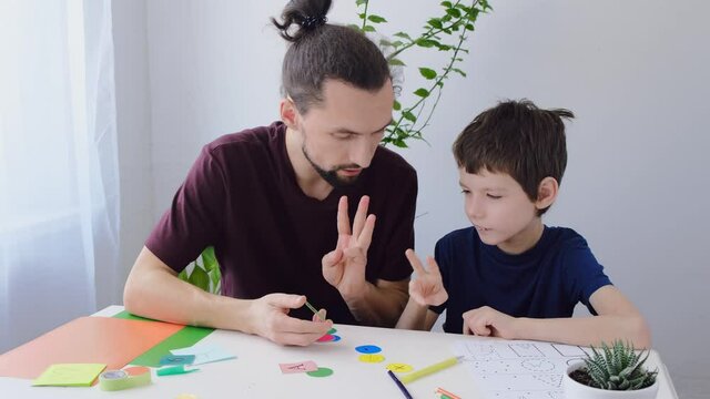 Happy autism boy during therapy with school tutor, learning together