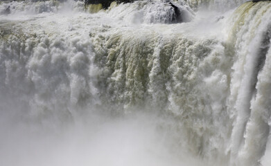 Natural background. Power in water. Closeup view of the famous Iguazu falls in Misiones, Argentina. The mist and falling white water beautiful texture, motion and pattern. 