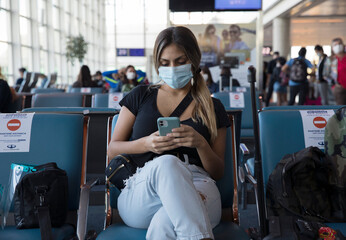 Coronavirus and social distancing. Traveling during pandemic. Young woman  wearing a protective...