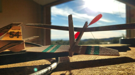 Balsa Wood Toy Airplane with Red Prop in Garage
