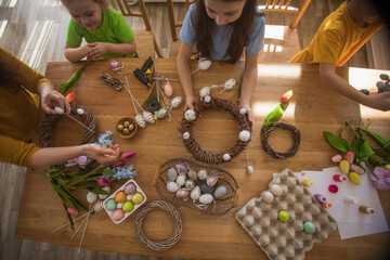 Making homemade Easter wreath of vines decorated with eggs
