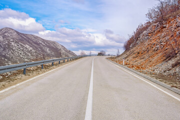 Balkan road trip.  Mountain landscape with road in Dinaric Alps. Asphalted two-lane road with continuous dividing strip and guard rail.  Bosnia and Herzegovina, Republika Srpska