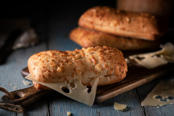 Cheese buns and sliced ​​cheese on a blue rustic table