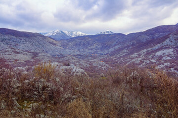 Fototapeta premium Beautiful mountain landscape on cloudy day in early spring. View of Orjen, Dinaric Mediterranean limestone mountain range. Montenegro