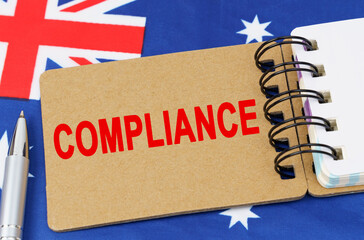 Against the background of the flag of Australia lies a notebook with the inscription - COMPLIANCE