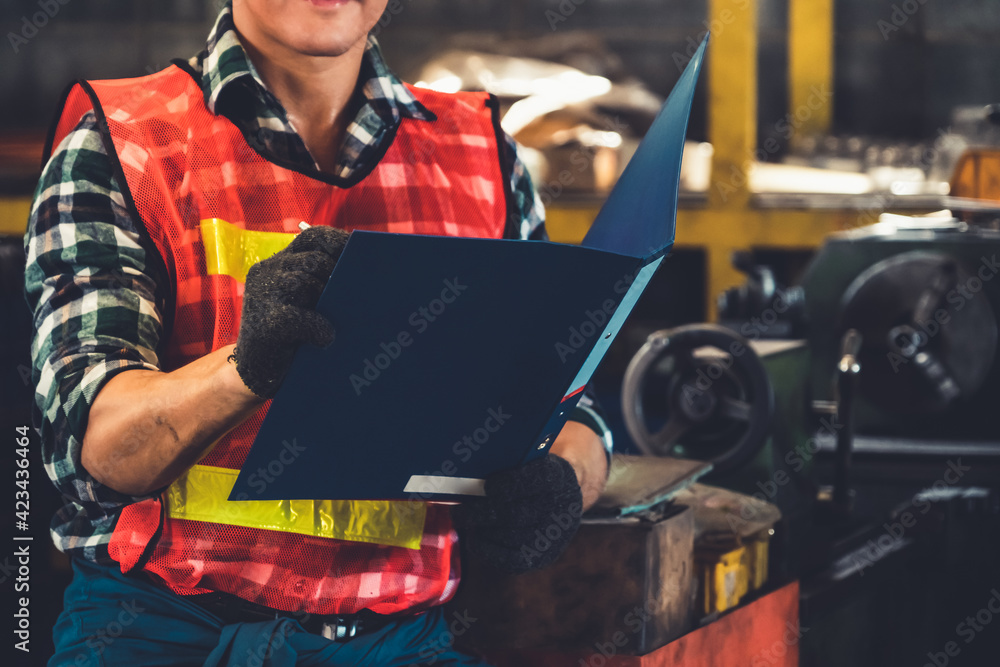 Poster manufacturing worker working with clipboard to do job procedure checklist . factory production line 