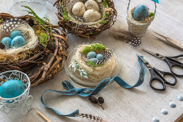 Pastel three colored easter eggs in the nest with cuckooflower in the background isolated on white