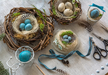 Pastel three colored easter eggs in the nest with cuckooflower in the background isolated on white