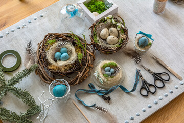 Pastel three colored easter eggs in the nest with cuckooflower in the background isolated on white