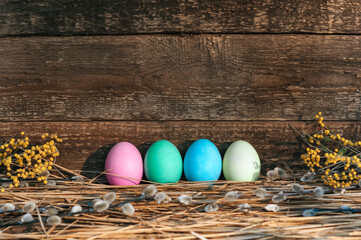A row of beautiful Easter eggs, near the old wooden wall Svetkomi willow.