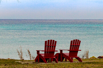 Red Adirondack chairs on the Beach