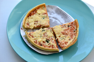 Cheap little pizza with cheese close-up on a plate
